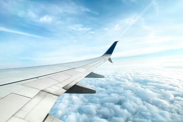 Photo of an airplane wing hovering over clouds in the sky.