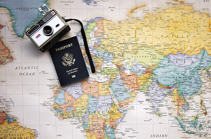 A world map featuring a travel passport and camera, highlighting the excitement of travel and discovery.