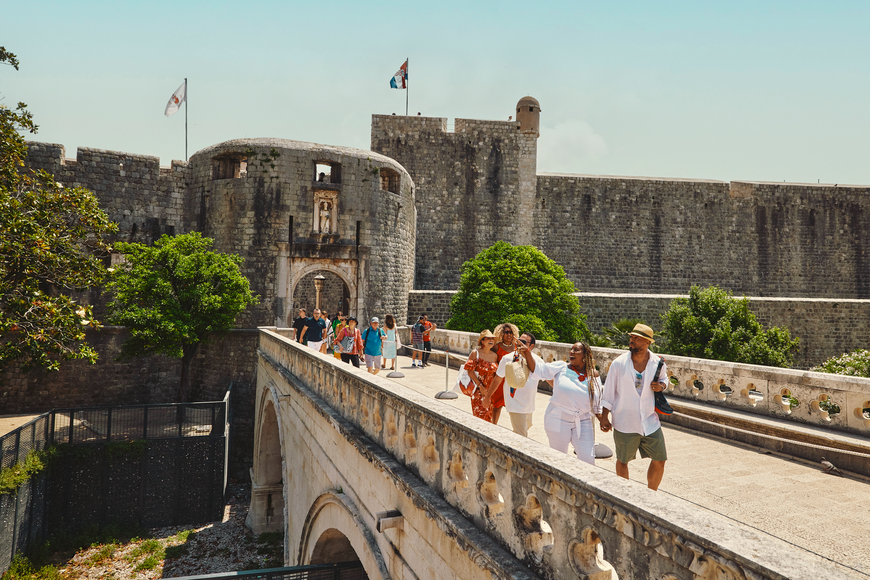 Photo of cruise travelers on an an ancient bridge in Dubrovnik, Croatia.
