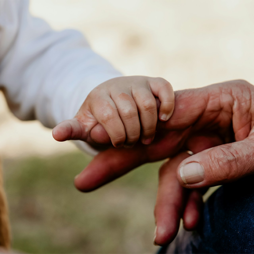 Baby and grandparent holding hands outdoors — multigenerational family vacation planning by Antoinette Harris of My Tailored Escape, luxury travel advisor serving Washington DC, Maryland, Virginia and nationwide