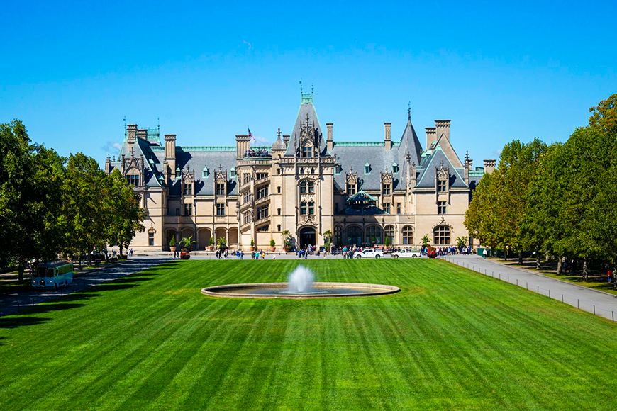Historic Biltmore Estate framed by fall trees and manicured lawns in Asheville, North Carolina, one of the best places to visit for fall foliage in the US, by My Tailored Escape, boutique travel agency serving Washington DC, Maryland, Virginia and nationwide.